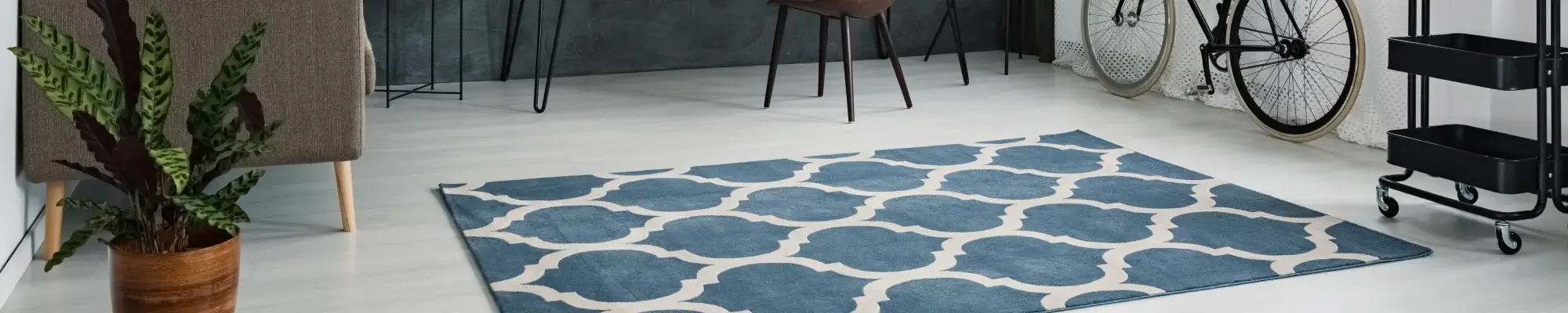 Modern neutral flooring with a blue and white area rug